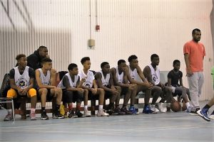 The Sun Youth Hornets watching intently the game being played in the Sun Youth Summer Camp Gymnasium. Photo Credit : Misé Johns 