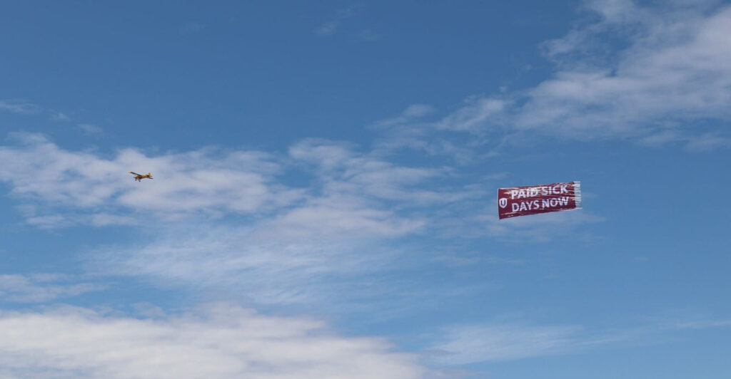 Unifor flies Paid Sick Days Now banner over Toronto